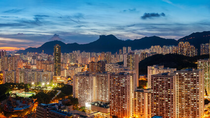 Naklejka na ściany i meble Panorama of Hong Kong city skyline and mountain Lion Rock at dusk