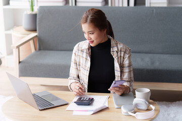 Asian accounting professional calculating household bills, reviewing and analyzing household bills, and filing tax returns.