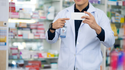 Pharmacy Drugstore. Portrait Professional Pharmacist handsome asian man showing the medicine box at pharma store. Health and wellness center