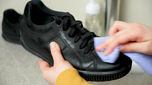 Cleaning black nubuck shoes with a damp cloth. Care for leather shoes.