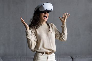 Beautiful young girl in virtual reality headset. Augmented Reality. Happy woman holds 3D vr glasses...