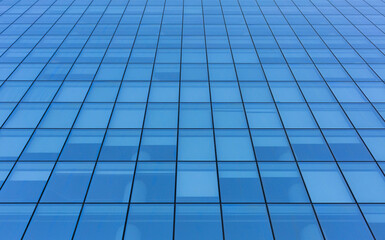 Fototapeta na wymiar Blue sky reflecting in windows of modern office building