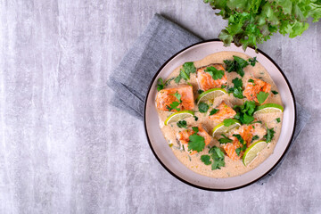 Fish curry with trout fillet pieces in sauce with coconut milk on plate.  Asian and Indian cuisine...