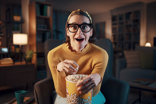 Woman watching a scary movie on TV