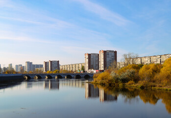 Panorama of the city in autumn. River and bridge and residential high-rise buildings