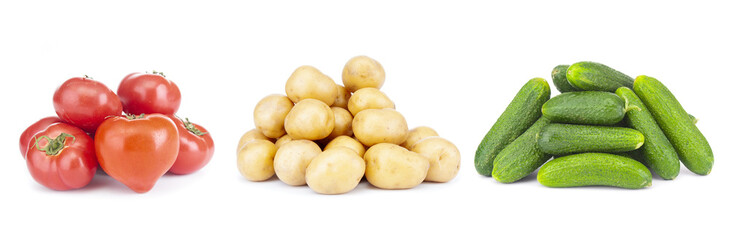 Heaps of vegetables- tomatoes, potatoes and cucumbers on white background