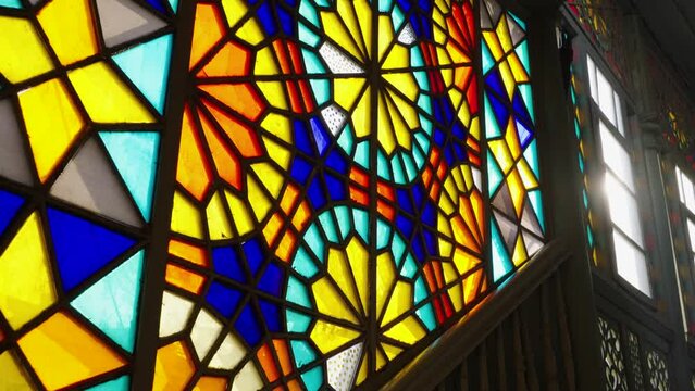 Vintage stained glass windows up the stairs with a ray of sun in the gap in a historic building or church, vintage front entrance in an old house, the concept of memories from the past