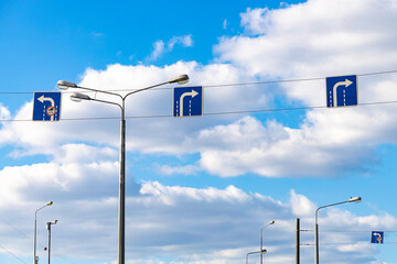 hanging road sign with an arrow indicating the direction of travel