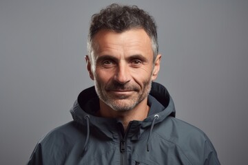 Portrait of a handsome mature man in a jacket on a gray background