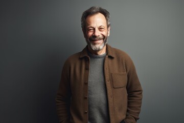 Obraz premium Portrait of mature man with grey hair and beard in brown jacket.