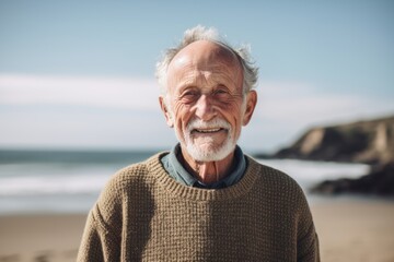 Portrait of smiling senior man standing on beach at the day time