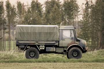 Classic oldtimer vintage four-wheel drive military truck on a country road