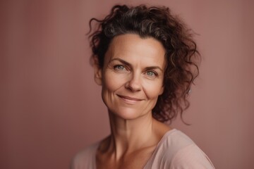 Portrait of a beautiful middle-aged woman on a pink background
