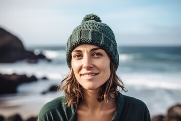 Portrait of smiling woman standing by the ocean on a sunny day