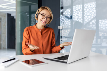Businesswoman with video call headset talking to customers remotely, female worker smiling and...