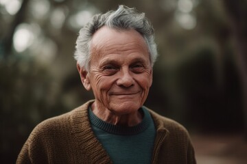 Portrait of senior man with grey hair smiling at camera in park