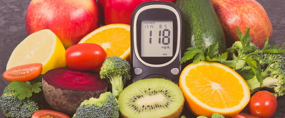 Glucometer for measuring sugar level and fruits with vegetables containing minerals and vitamins, diabetes and healthy lifestyles concept