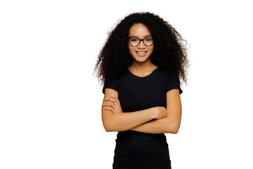 Slim satisfied woman with Afro haircut, wears black casual clothes, optical glasses, has confident expression, listens interlocutor, isolated on beige background. Cute teenage girl enjoys life.
