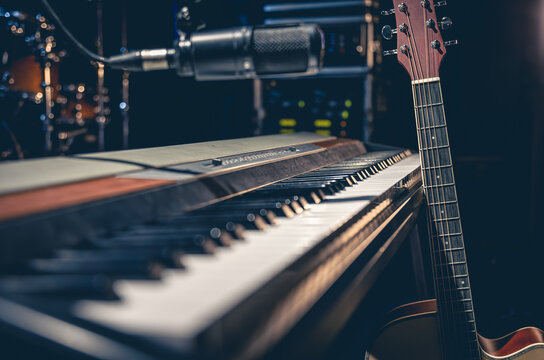 Musical keys, guitar and microphone on a dark background.