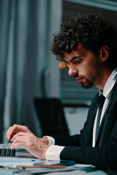 Serious entrepreneur working on latop in dark office late at night