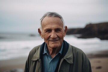 Fototapeta na wymiar Portrait of happy senior man standing on beach, looking at camera