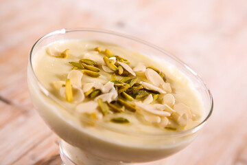 Kheer, firni or Mahalabia topping with almond, pistachio served in dish isolated on table top view...