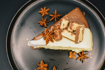 vanilla cream cake with white and black chocolates on the black background
