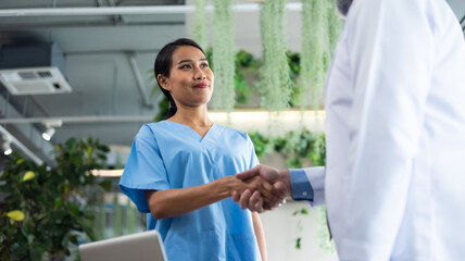 Surgeon medical and doctor people handshaking. Asian woman nurse shaking hands with doctor on a business cooperation agreement. healthcare and medicine