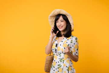 Portrait happy young asian woman with springtime dress fashion using mobile application for advertisement isolated on yellow background. Smartphone app technology concept.