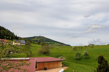 Mountains and farmhouses with photovoltaic modules on the roof under cloudy sky in Gresgen in the...