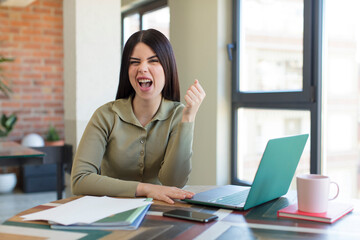 Fototapeta premium pretty young woman looking angry, annoyed and frustrated. laptop and desk concept