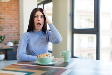 pretty young woman feeling extremely shocked and surprised. breakfast concept