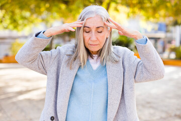 senior retired pretty white hair woman looking concentrated, thoughtful and inspired, brainstorming...