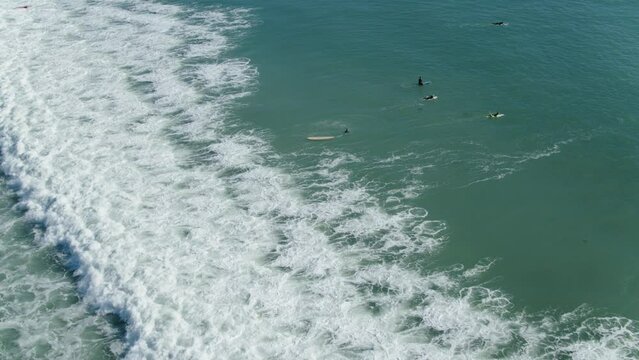 Aerial Of People Surfing On Sea Waves During Sunny Day, Drone Flying Over Surfers - San Juan Capistrano, California