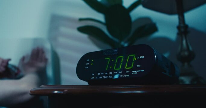 Man Wakes Up Early in the Morning to Turn Off the Activated Digital Alarm Clock on His Nightstand. Man Turns on the Light of a Table Lamp After Waking Up From Sleep.Cinematic Shot Digital Alarm Clock 