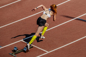 female sprinter start running from starting blocks in summer athletics championships