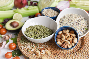 Pumpkin seeds, nuts and chia seeds and other healthy foods on the kitchen table.
