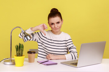 Displeased woman office worker showing thumbs down, dislike gesture, expressing disapproval,...