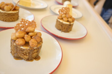 Small round homemade toffee cake topped with macadamia nuts. Topped with sweet caramel and chocolate slices. Many delicious toffee macadamia nut cake serving to customers. popular dessert

