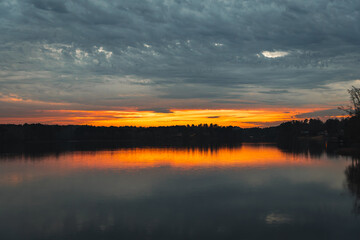 Obraz premium beautiful sunset with the reflection of the forest trees in the lake