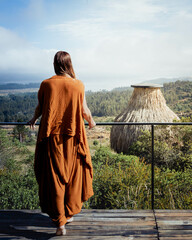 Mujer con traje naranja contempla la naturaleza