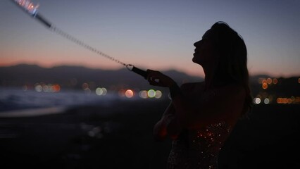 Attractive woman fire dancer spinning flames at the beach. Slow Motion.