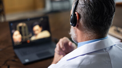 Close up headset. Back view. Senior caucasian doctor online video call conference with headset consult patient on laptop computer. Doctor online consultation and telehealth medicine