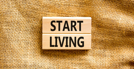 Start living symbol. Concept words Start living on beautiful wooden block. Beautiful canvas table canvas background. Business and Start living concept. Copy space.