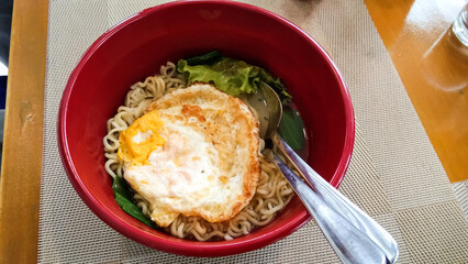 a bowl of instant noodles with sunny side up eggs