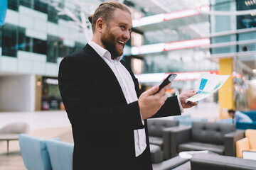 Cheerful businessman with smartphone and document