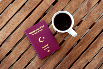 Turkish passport with coffee cup on wooden table photographed from above