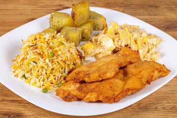 .Breaded chicken served with sweet potatoes, biro biro rice and egg farofa. Brazilian food usually served as an executive dish.