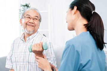 Contented senior patient doing physical therapy with the help of his caregiver. Senior physical...