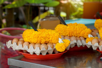 Eggs, marigold flower garlands and sticks of incense sticks are placed on trays to be offered as offerings to sacred objects when the request is fulfilled, which is the belief of some Asians.